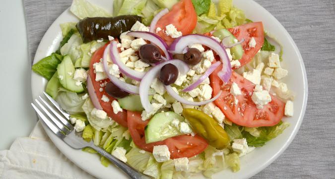 Greek Salad · Lettuce, feta, tomatoes, cucumbers, onions, dolma, peppers and black olives with our home made vinaigrette. Served with warm pita.