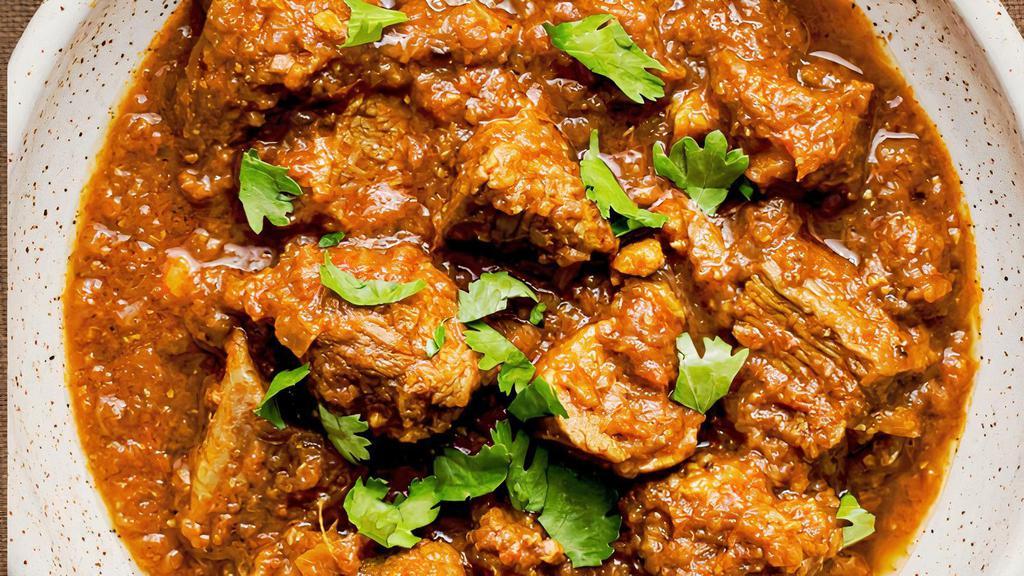 Goat Curry · Tender goat meat cooked in an onion tomato gravy with aromatic whole spices.