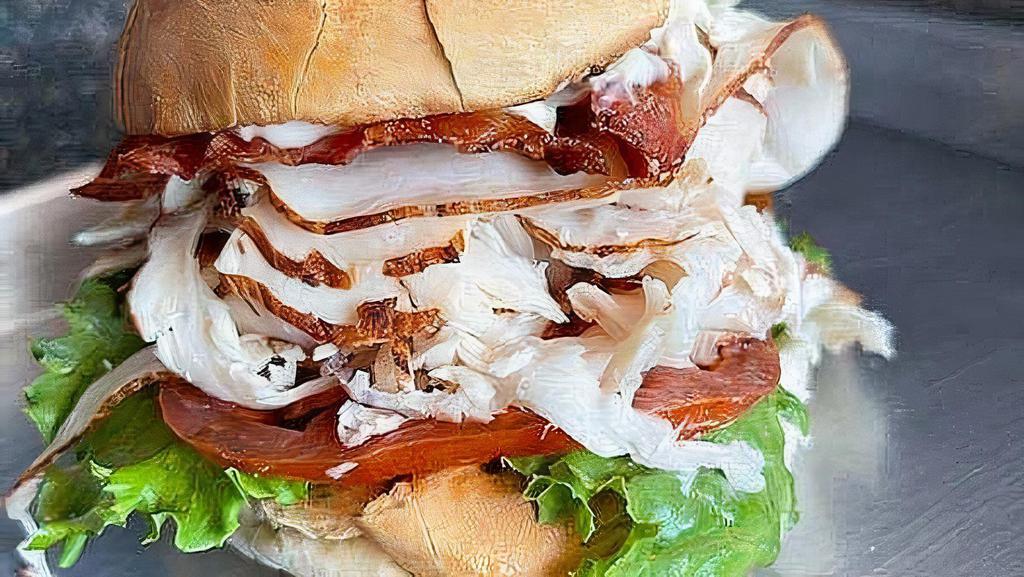 The Orange Pack · Club sandwich with choice of roast turkey or breaded chicken with mayo, lettuce, tomatoes, and bacon on a giant kaiser roll.
