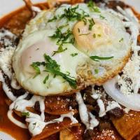 Chilaquiles · Golden corn tortillas sautéed and simmered in tomatillo sauce with onions, cheese, sour cream.