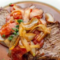 Bistec Encebollado · Beef steak topped with sauteed onions and tomatoes.
