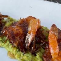 Camarones Al Coco · Coconut-crusted shrimp served over avocado salsa topped with citrus ginger glaze.