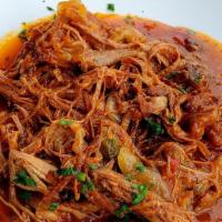 Ropa Vieja · Slow roasted and shredded flank steak with peppers and onion in criollo sauce.