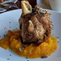 Baby Pernil (Our Specialty!) · Slow roasted pork shank, with a crispy crust topped with garlic and sour orange mojo, served...