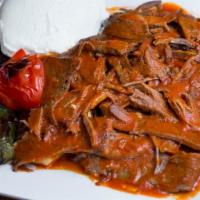 Iskender Kebab · Vertically grilled lamb sliced very thin, served with garlic, yogurt and tomato sauce over p...