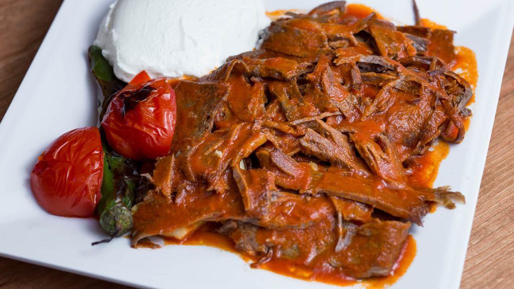 Iskender Kebab · Vertically grilled lamb sliced very thin, served with garlic, yogurt and tomato sauce over pita bread. Served with pita bread, vegetables, lettuce, onions, tomato and red cabbage.