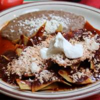 Chilaquiles · Small pieces of deep fry corn tortillas and covered with green or red spicy sauce topped wit...