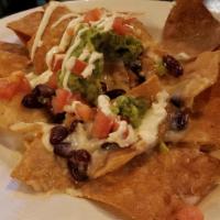 Loaded Nachos · Topped with ground beef, sausage, red beans, melted cheese, sour cream, tomatoes, guacamole.