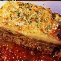Moussaka · Layers of sliced potatoes, zucchini and seasoned chopped meat topped with a creamy bechamel ...