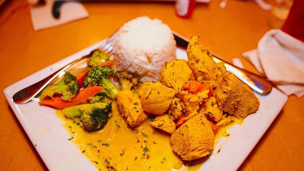 Boneless Curry Chicken · Caribbean style curry chicken served with white rice, steamed vegetables.