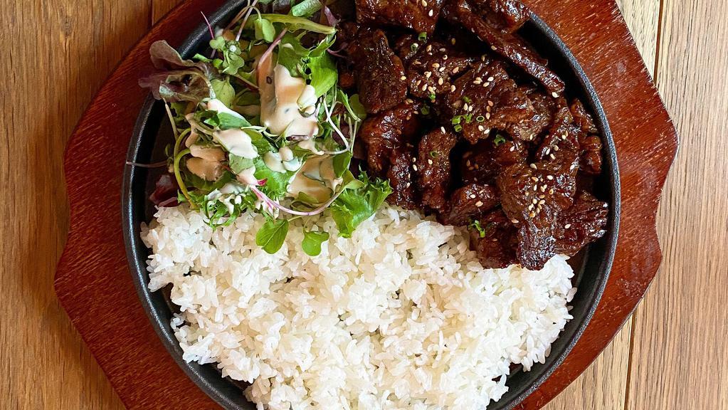 Galbi Rice / 갈비덮밥 · Traditional marinated beef short ribs over rice on a sizzling stone pan.