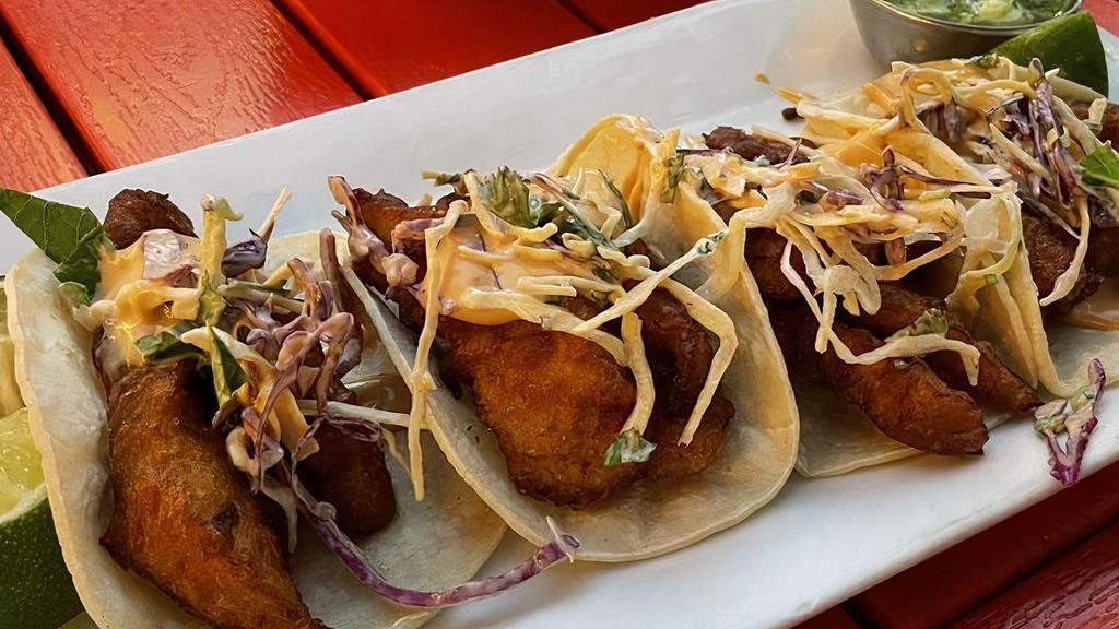 Pescado Tacos · Top menu item. Beer buttered tilapia fish, topped with cabbage slaw, chipotle aioli, and avocado salsa.
