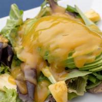 Ensalada De Pina Y Aguacate · Avocado and pineapple in a mango vinaigrette on a bed of mixed greens.
