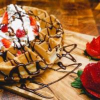 Crown Waffle · Belgian waffle, Nutella sauce, pecans, strawberries, whipped cream.