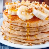 Banana Pancakes · Fluffy, buttery pancakes marbled and topped with fresh banana slices. Served with real butte...