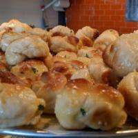 Garlic Knots · Served with a side of sauce.