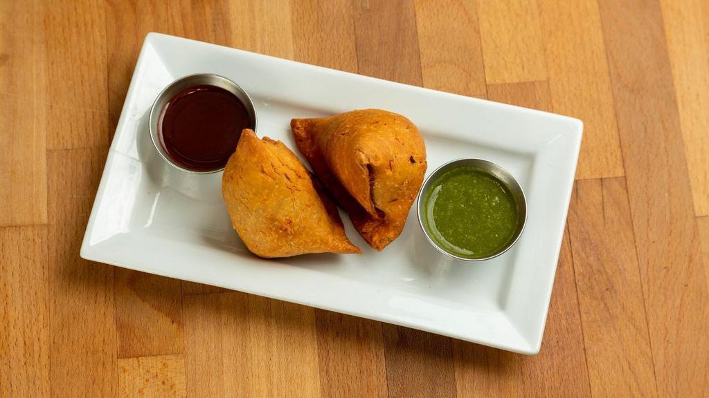 Samosa · Deep fried pastry with savory potato and cauliflower filling, served with mint and tamarind chutnies on the side