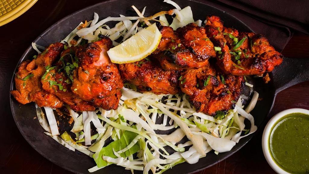 Murgh Tikka · Skewered chicken thighs in a spiced yogurt marinade, cooked to perfection in a tandoor oven (20 minutes preparation time)