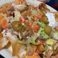 Chicken Nachos · Melty nachos loaded with chicken, melted cheese, pico de gallo, and your choice of additiona...