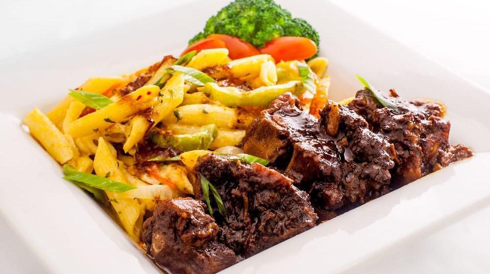 Oxtail Reggae Pasta · Pasta marinated in homemade alfredo sauce onions carrots green peppers and island cz spice. served with plantains your choice of rice and your choice of steamed vegetables or garden salad.