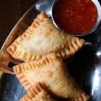Curry Puffs · Pan fried savory pastries with spiced potatoes served with sweet chili sauce.