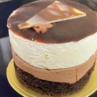 Triple Layer Mousse · A layer of rich chocolate cake, dark chocolate mousse, and white mousse, topped with chocola...