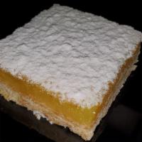 Lemon Square · Tart lemon squares topped with fine powdered sugar on a soft flaky crust
