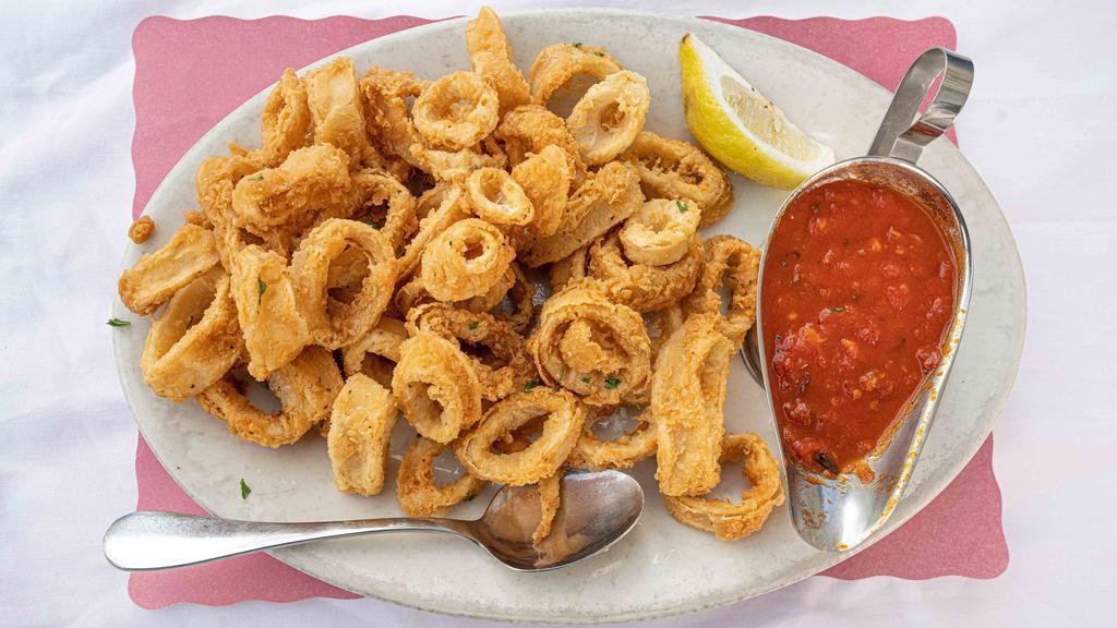 Fried Calamari · Golden fried calamari served with a side of  marinara sauce & lemon.