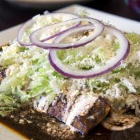 Enchiladas De Mole Poblano · Three soft corn tortilla rolled with choice of stuffing and mole sauce topped with Mexican c...