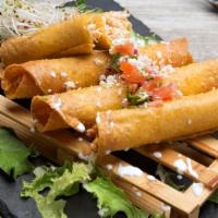 Flautas · 4 crispy corn tortilla rolls topped with pico de gallo, cotija cheese choice of chicken, gal...