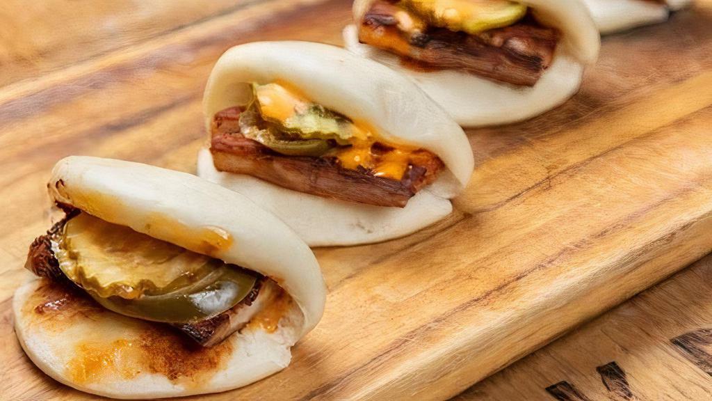 Pork Belly Bao Buns · Steamed, Pillowy Bao Buns Stuffed With Melt In Your Mouth Pork Belly, Pickled Cucumber, Jalapeno + Sriracha Mayo. (4 Pieces).