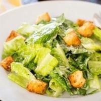 Caesar Salad · Crispy romaine lettuce blended with Caesar dressing and croutons topped with shaved Grana Pa...
