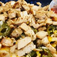 Loaded Nachos Grande · Melted Cheddar cheese, homemade chili or grilled chicken, tomatoes, and jalapeños on a pile ...