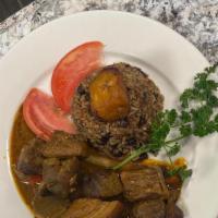 Cerdo Guisado/ Stewed Pork · Con Arroz y habichuelas/ With Rice and Beans