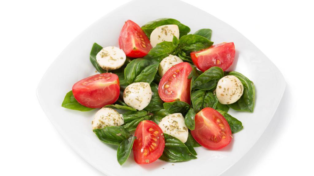 Fresh Tomato & Mozzarella · A side dish made with fresh tomatoes and mozzarella cheese, served with basil oil and arugula.