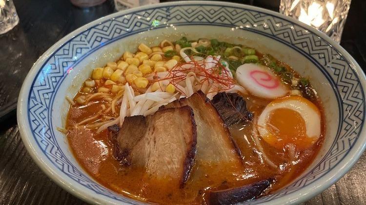 Spicy Miso Ramen · Pork belly, 1/2 soft boiled egg, scallion, fish cake, corn, bean sprouts, pork broth and thin noodles.