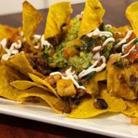 Super Nachos · Crisp tortilla chips covered with chili, cheddar, Monterey Jack. cheeses, fresh pico de gall...