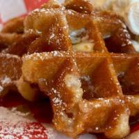Belgium Waffles · 2 Belgium waffles served with butter, syrup, powdered sugar & a dollop of whipped cream