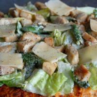Chicken Caesar Pizza · Topped with romaine lettuce, grilled chicken, creamy Caesar dressing, and grated Parmesan.