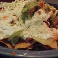 Nachos · Crispy tortilla layered with beans and Monterey mustard cheese topped with lettuce, tomatoes...