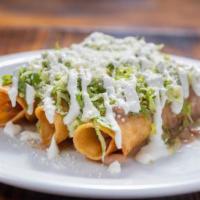 Flautas De Chori Papa · 2 crispy tortilla rolls filled with chorizo and potatoes topped with refried beans, tomatill...