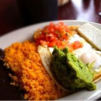 Huevos Rancheros · Two over-easy eggs with guacamole, pico de gallo, and queso fresco on a lightly fried corn t...
