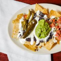 Nachos Sin Carne · Top menu item. Plain. A mound of corn tortilla chips topped with refried black beans, guacam...