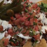 Nachos Con Pollo · Top menu item. Spicy chicken. A mound of corn tortilla chips topped with refried black beans...
