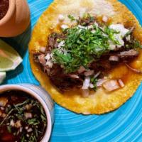 Beef Birria · Braised beef topped with cilantro and onions, served with a side of beef consumee.