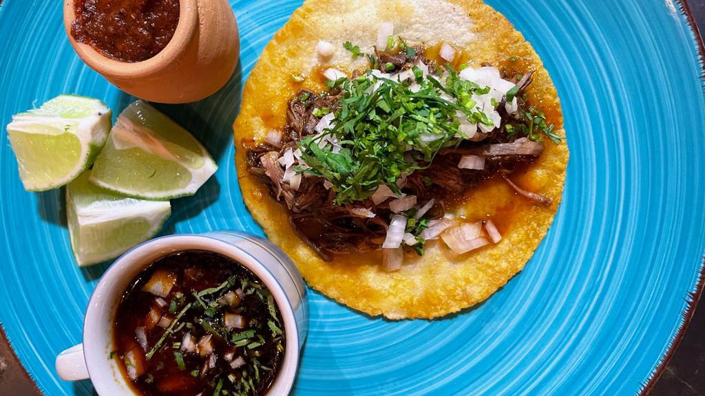 Beef Birria · Braised beef topped with cilantro and onions, served with a side of beef consumee.
