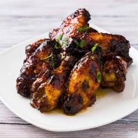 Mango Habenero Wings · Charred grilled wings cooked in mango habanero sauce.