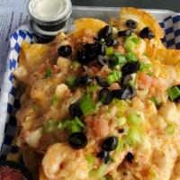 Seafood Lovers Nachos · Topped with lobster, shrimp, crab and scallops in a creamy garlic sauce.