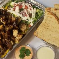 Jerk Chicken Over Rice · Jerk chicken over rice or mixed with lettuce and a Mediterranean salad. Served with pita and...
