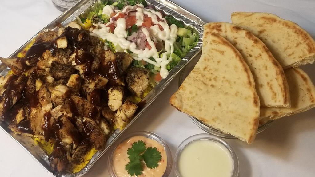 Jerk Chicken Over Rice · Jerk chicken over rice or mixed with lettuce and a Mediterranean salad. Served with pita and soda.